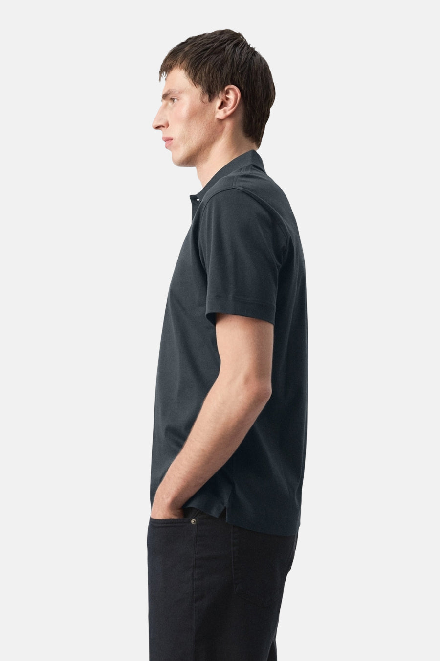 Blauw poloshirt van MANGO, in zijaanzicht gedragen met een donkere broek.
