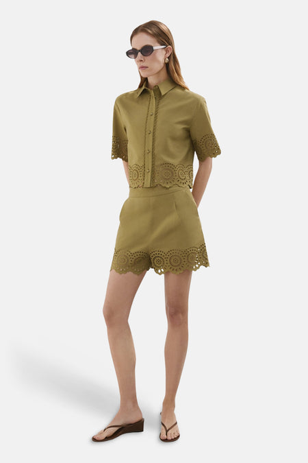 Korte, kaki blouse van MANGO met cirkelvormig opengewerkt borduursel en geschulpte zomen, gedragen als set.