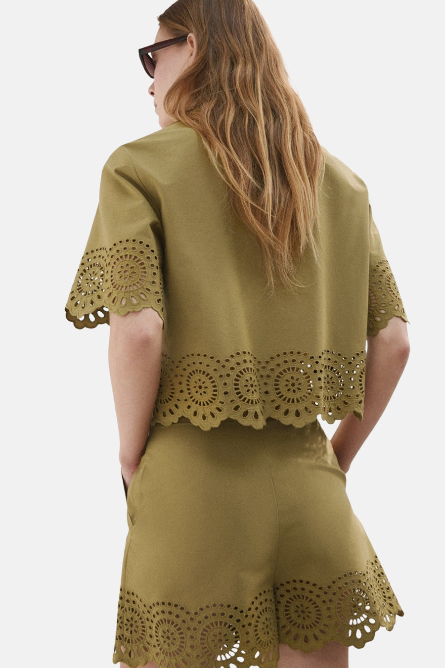 Khaki blouse met korte mouwen van MANGO met lasergesneden cirkeldetails en bijpassende short, van achteren gezien.