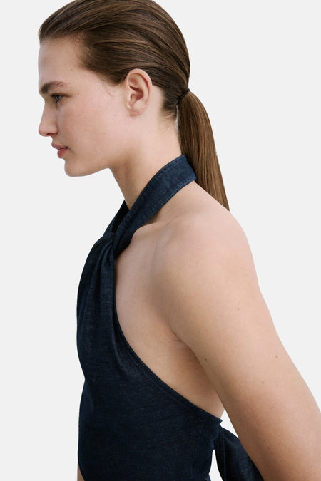 Donkerblauwe denim top van MANGO met gedraaide halternek, mouwloos, zijprofiel.