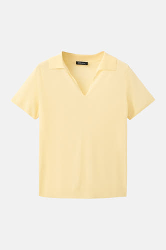 Gele polo met korte mouwen van MANGO, met V-hals en platte kraag, liggend gefotografeerd.
