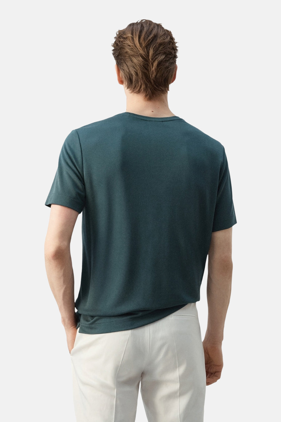 Groen T-shirt met korte mouwen van MANGO, gedragen door een man in crème-witte broek, achteraanzicht.