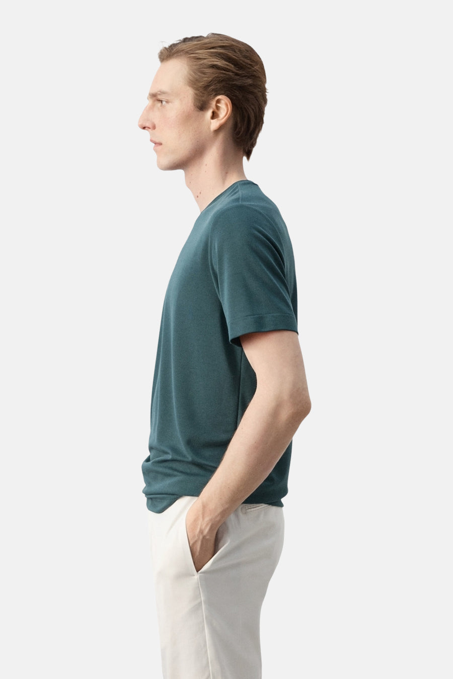 Groen T-shirt met korte mouwen van MANGO, gedragen door een man met handen in lichte broekzakken, zijaanzicht.