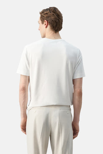 Wit T-shirt met korte mouwen van MANGO, gedragen aan de rugzijde door een man met een beige broek.