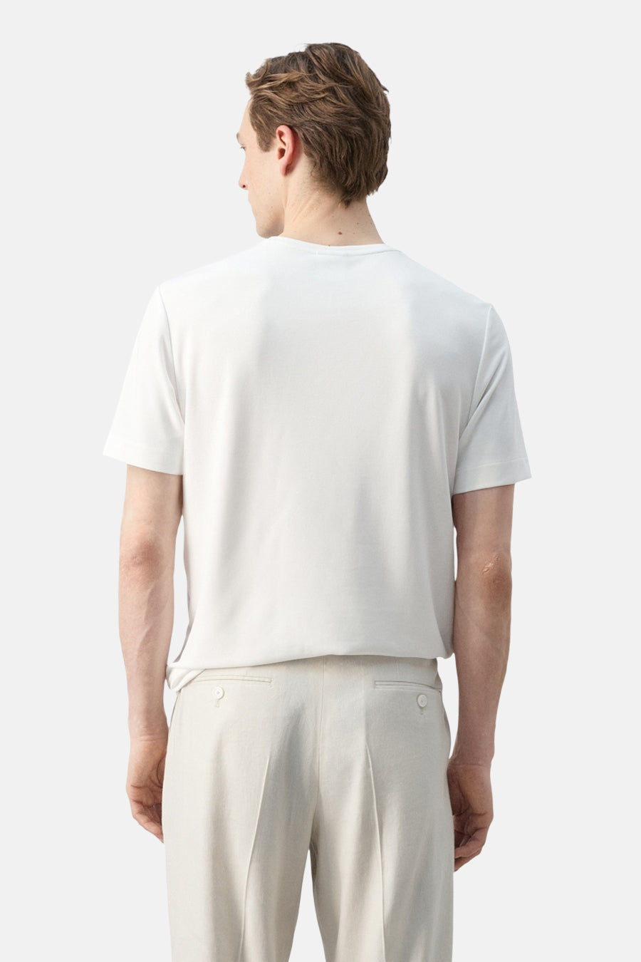 Wit T-shirt met korte mouwen van MANGO, gedragen aan de rugzijde door een man met een beige broek.