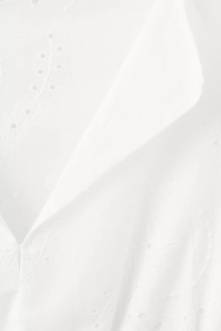 Detailopname van een wit kleedje met lange mouwen van MANGO, met broderie anglaise en subtiele plooien.