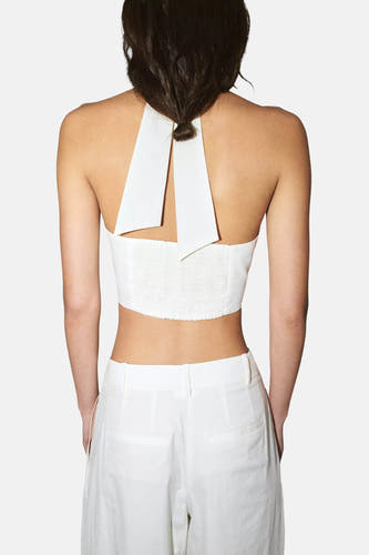 Witte mouwloze blouse met ruchedetail en V-hals van MANGO, achterkant weergegeven, model draagt witte broek