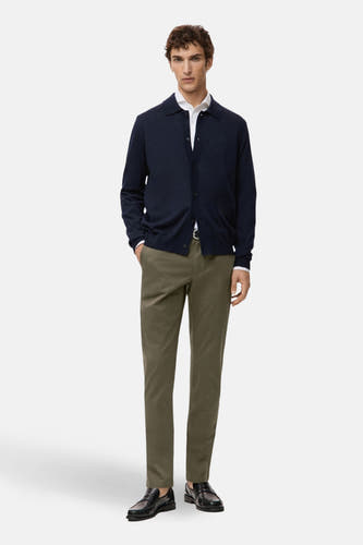 Chino vert de MANGO, associé à une chemise blanche et un gilet bleu marine.