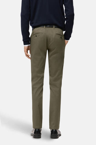 Groene chino van MANGO, gezien van achteren, met een donkerblauwe trui en zwarte schoenen.
