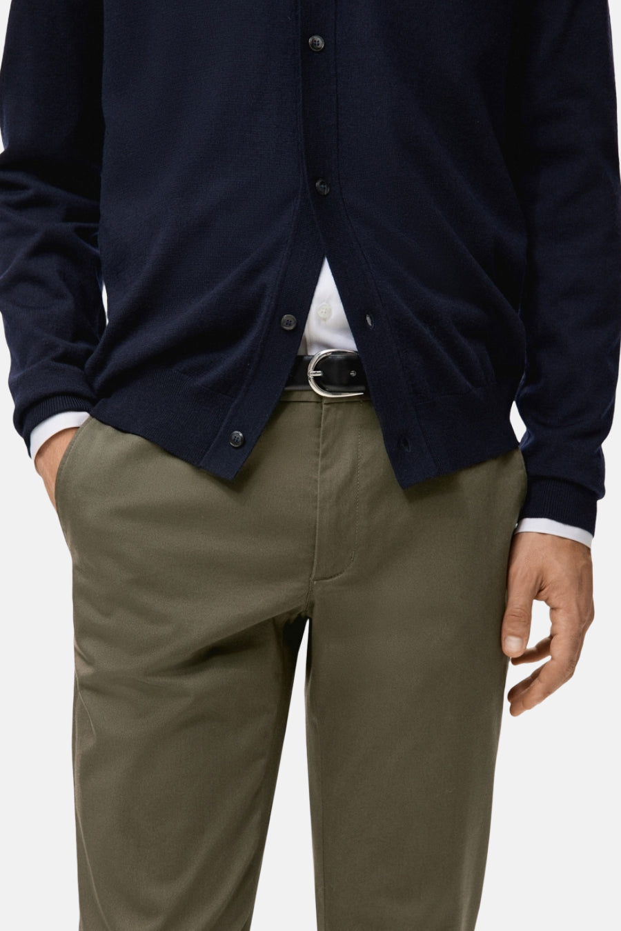 Chino vert de MANGO, avec une ceinture noire et un gilet bleu marine.