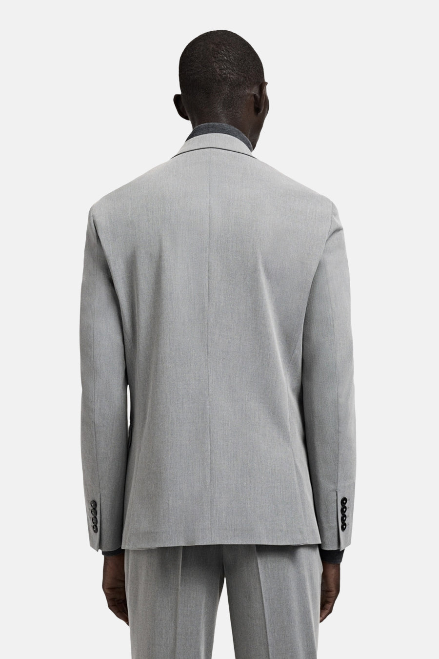 Grijze blazer van MANGO, gezien vanaf de achterkant, met donkere knopen aan de manchetten en een subtiele textuur.