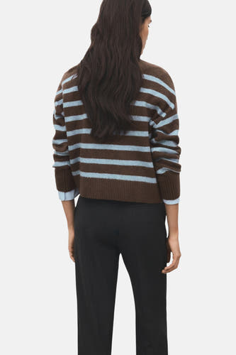 Veelkleurige trui met ronde hals van MANGO, met bruine en lichtblauwe strepen, gecombineerd met een zwarte broek.
