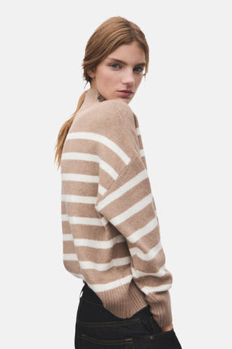 Beige trui met ronde hals van MANGO, gestreept patroon en gedragen met donkere jeans.
