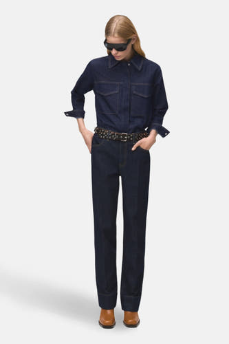 Donkerblauw denim overhemd met lange mouwen van MANGO, met twee borstzakken en gedragen met een riem.
