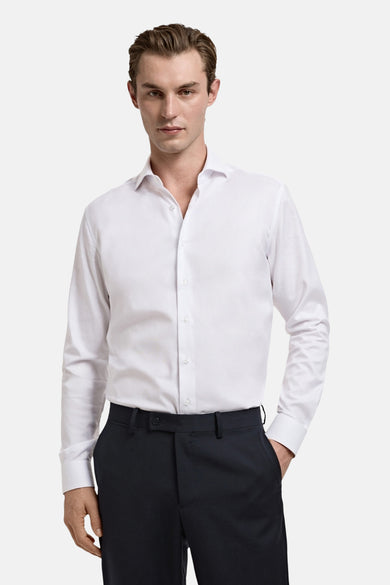 Wit overhemd met lange mouwen van MANGO, gedragen met donkere pantalon.