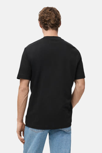 T-shirt noir à manches courtes de MANGO, vu de derrière, associé à un jean bleu.