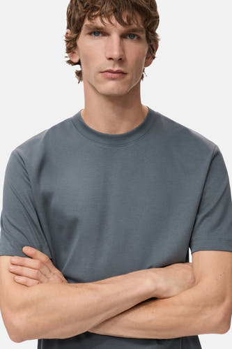 Blauw T-shirt met korte mouwen van MANGO, met gekruiste armen van een model.
