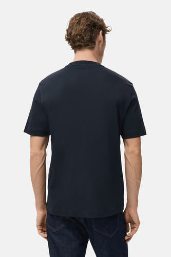 Blauw T-shirt met korte mouwen van MANGO, gezien van achteren, gecombineerd met een donkere jeans.
