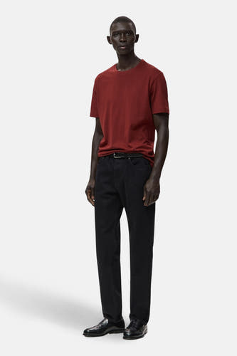 Rood T-shirt met korte mouwen van MANGO, gedragen met zwarte jeans en leren loafers.
