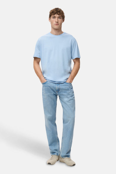 T-shirt bleu à manches courtes de MANGO, porté avec des jeans et des baskets blanches.