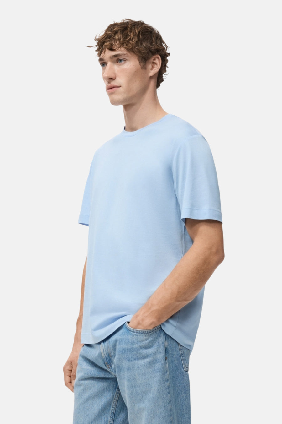 Blauw T-shirt met korte mouwen van MANGO, gedragen met een blauwe jeans, in zij aanzicht.