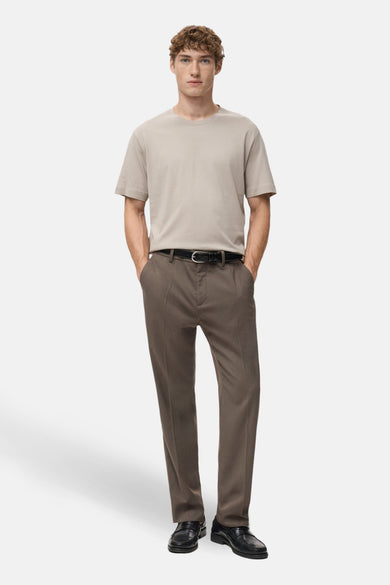 Beige T-shirt met korte mouwen van MANGO, gedragen met een bruine pantalon en zwarte leren riem.