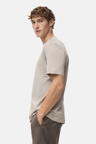 Beige T-shirt met korte mouwen van MANGO, zij aanzicht, met bruine broek.