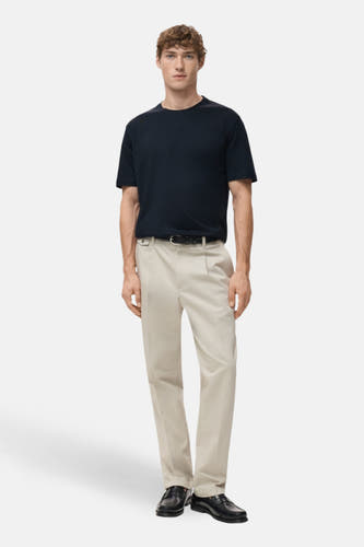 Blauw T-shirt met korte mouwen van MANGO, gedragen met een beige pantalon, riem en zwarte schoenen.