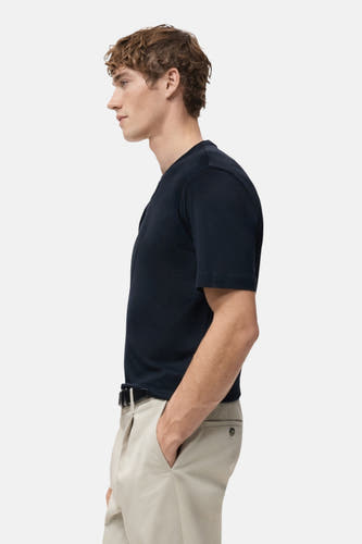 Blauw T-shirt met korte mouwen van MANGO, in zij-aanzicht met kaki broek en riem.
