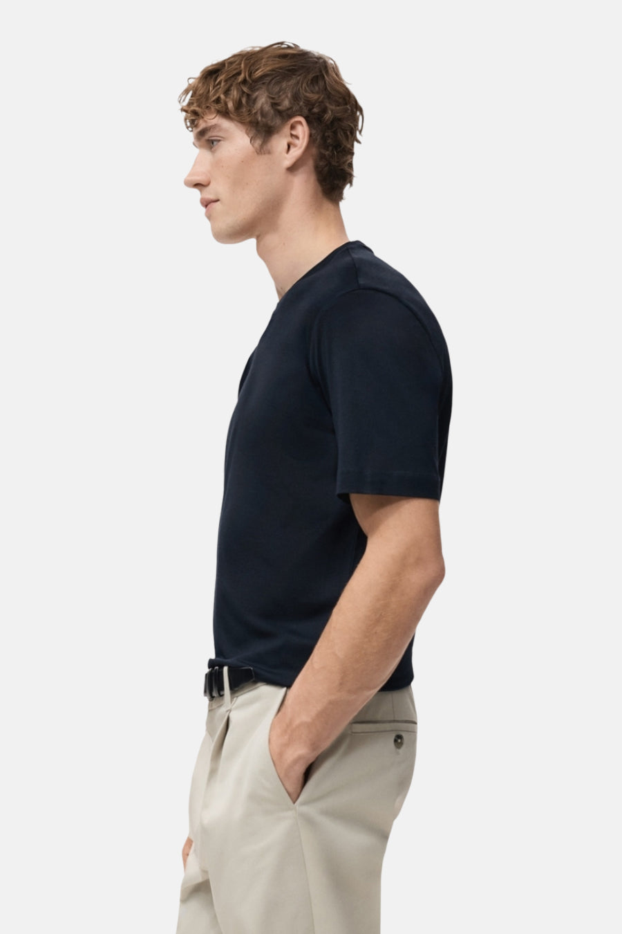 Blauw T-shirt met korte mouwen van MANGO, in zij-aanzicht met kaki broek en riem.
