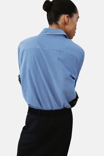 Blauw gestreept overhemd met lange mouwen van MANGO, gezien van achteren, met zwarte pantalon.