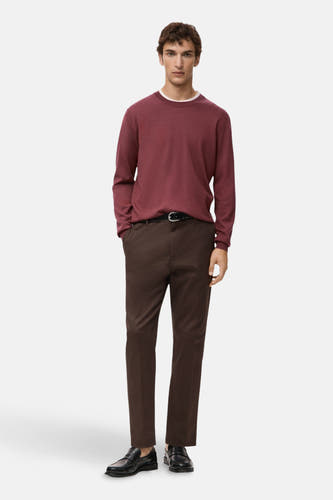T-shirt rouge avec col rond de MANGO, porté avec un pantalon marron et une ceinture noire et des chaussures.