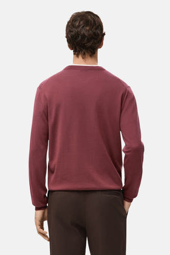 Rode trui met ronde hals van MANGO, gezien van achteren, gecombineerd met bruine pantalon.