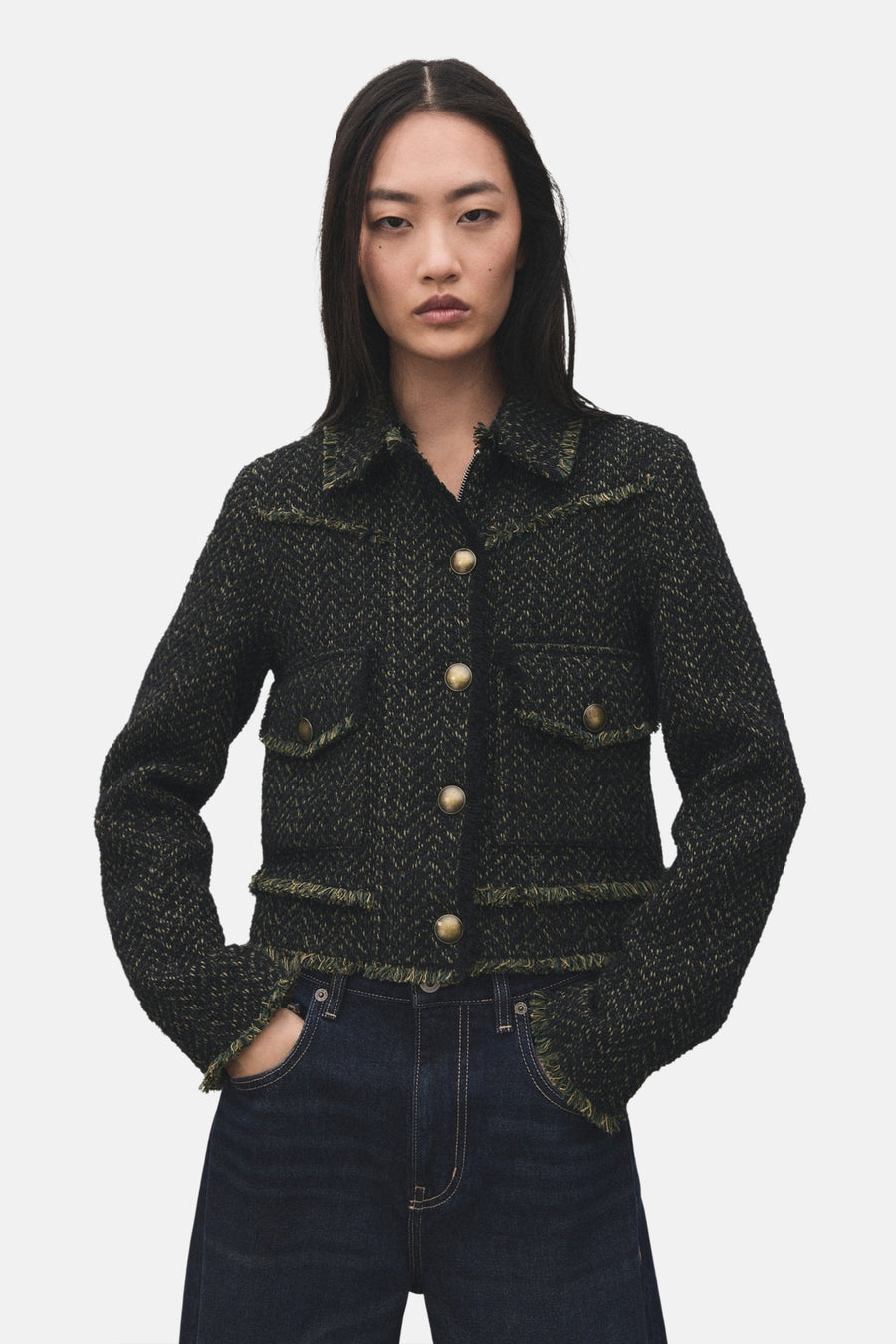 Blazer vert de MANGO, met een geweven textuur en gerafelde details, gedragen met een donkerblauwe jeans.