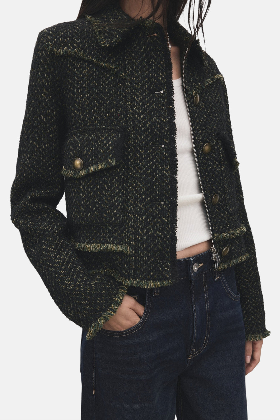 Blazer vert de MANGO avec une texture tweed-like et des détails froncés, associé à un haut blanc et un jeans foncé.