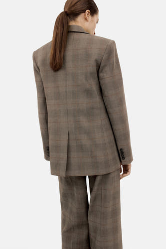 Bruine blazer van MANGO, met een ruitpatroon en knoopdetails op de mouwen, gezien van achteren.
