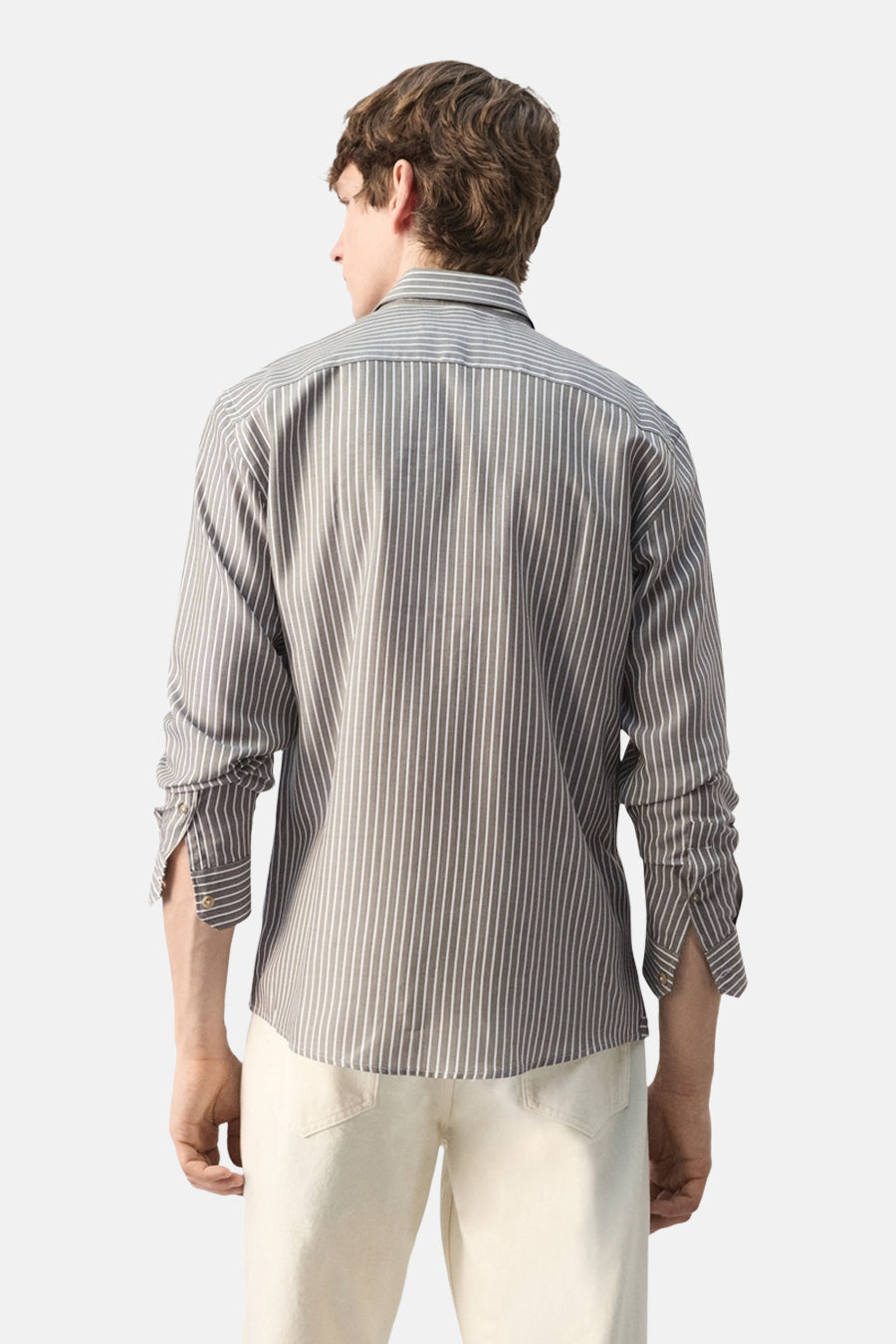 Kaki gestreept overhemd met lange mouwen van MANGO, met omgeslagen mouwen en beige pantalon.
