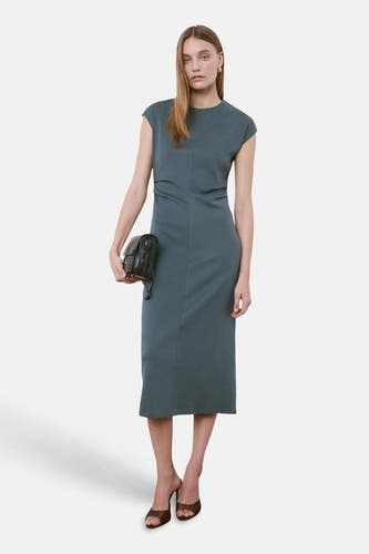 Robe bleue sans manches de MANGO, avec une longueur au-dessus du genou et des mules marron.