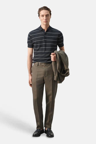 Polo noire de MANGO, avec des rayures horizontales blanches, combinée avec un pantalon kaki et des chaussures noires.