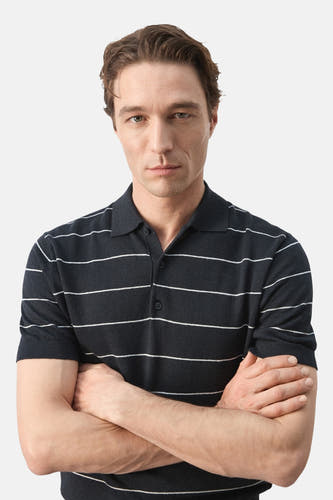 Polo noire MANGO à motif rayé, manches courtes et bras croisés.