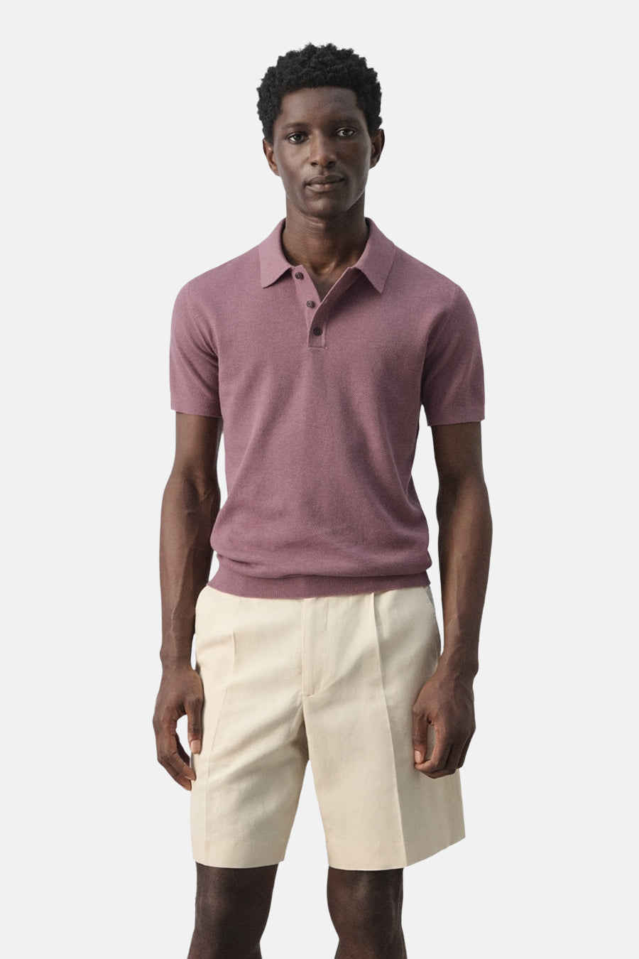 Paarse polo van MANGO, met korte mouwen, gedragen met beige shorts.