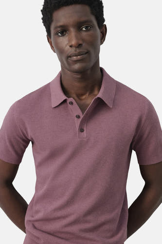 Paarse polo van MANGO, met korte mouwen en knoopsluiting, getoond op een model tegen een effen achtergrond.
