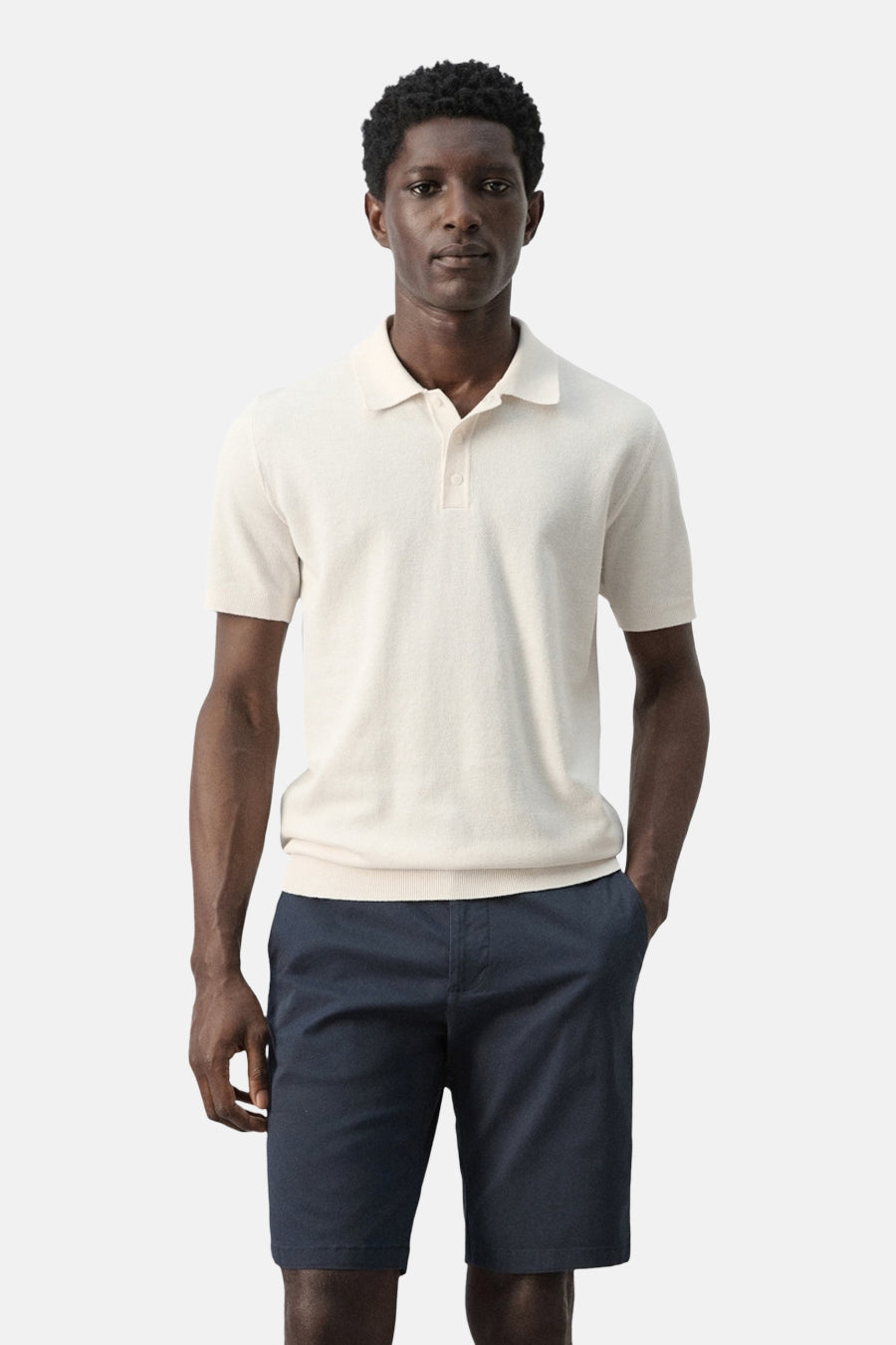 Ecru polo van MANGO, met korte mouwen en gedragen met blauwe shorts.