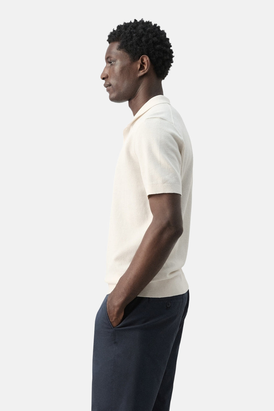 Ecru polo van MANGO, zijaanzicht, met korte mouwen en donkerblauwe broek.
