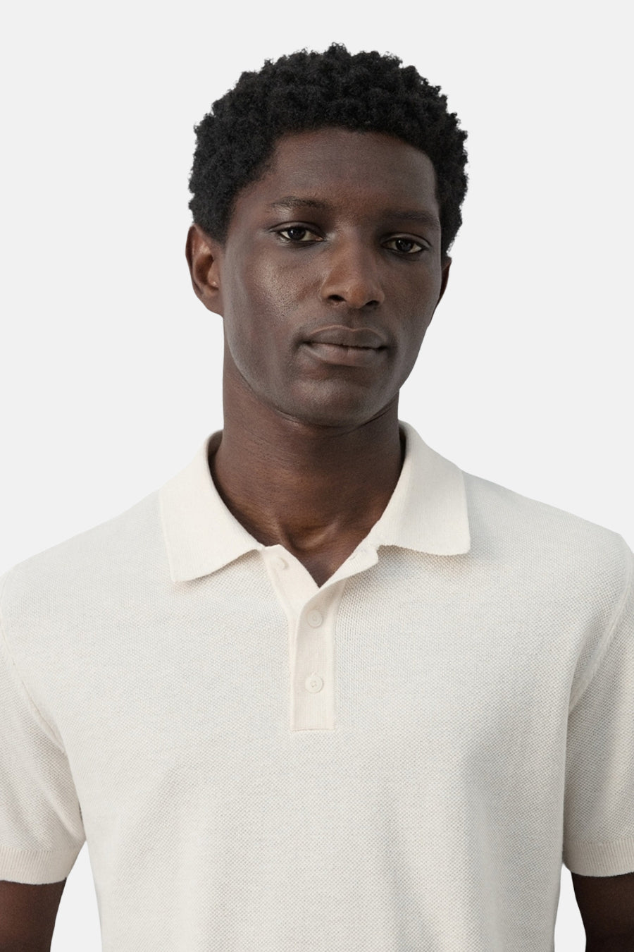 Ecru polo van MANGO, close-up, met korte mouwen en knoopsluiting.