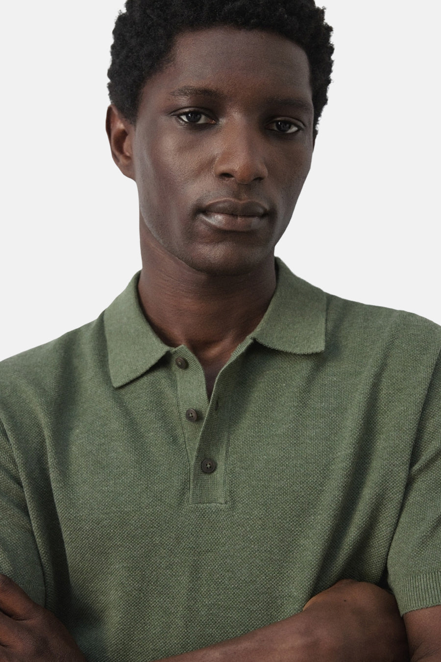 Groene polo van MANGO, met korte mouwen en een slanke pasvorm, gedragen door een man.
