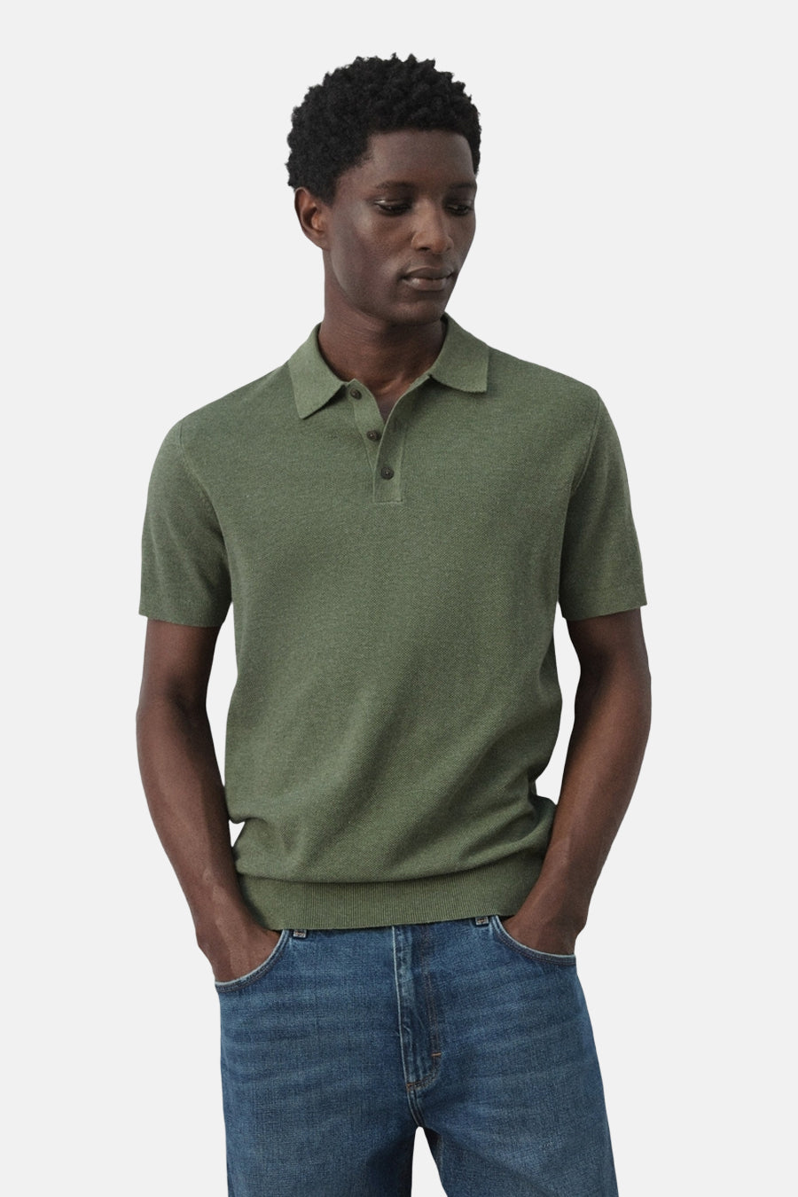 Groene polo van MANGO, met korte mouwen en een klassieke kraag, gedragen met jeans.
