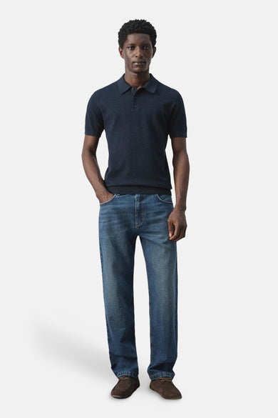 Polo bleue de MANGO, portée avec un jean et des chaussures en daim.