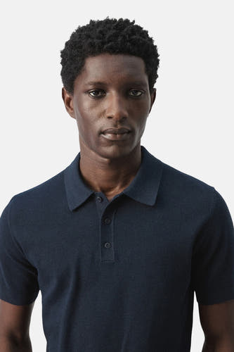 Blauwe polo van MANGO, met korte mouwen en een fijne structuur.
