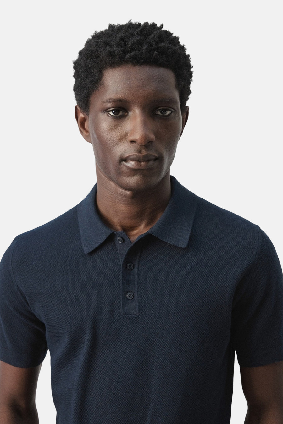 Blauwe polo van MANGO, met korte mouwen en een fijne structuur.